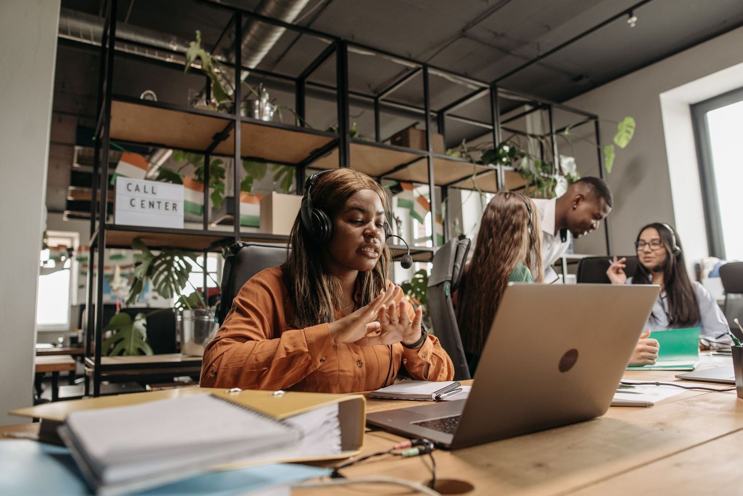 An agent with a headset working with her team behind her