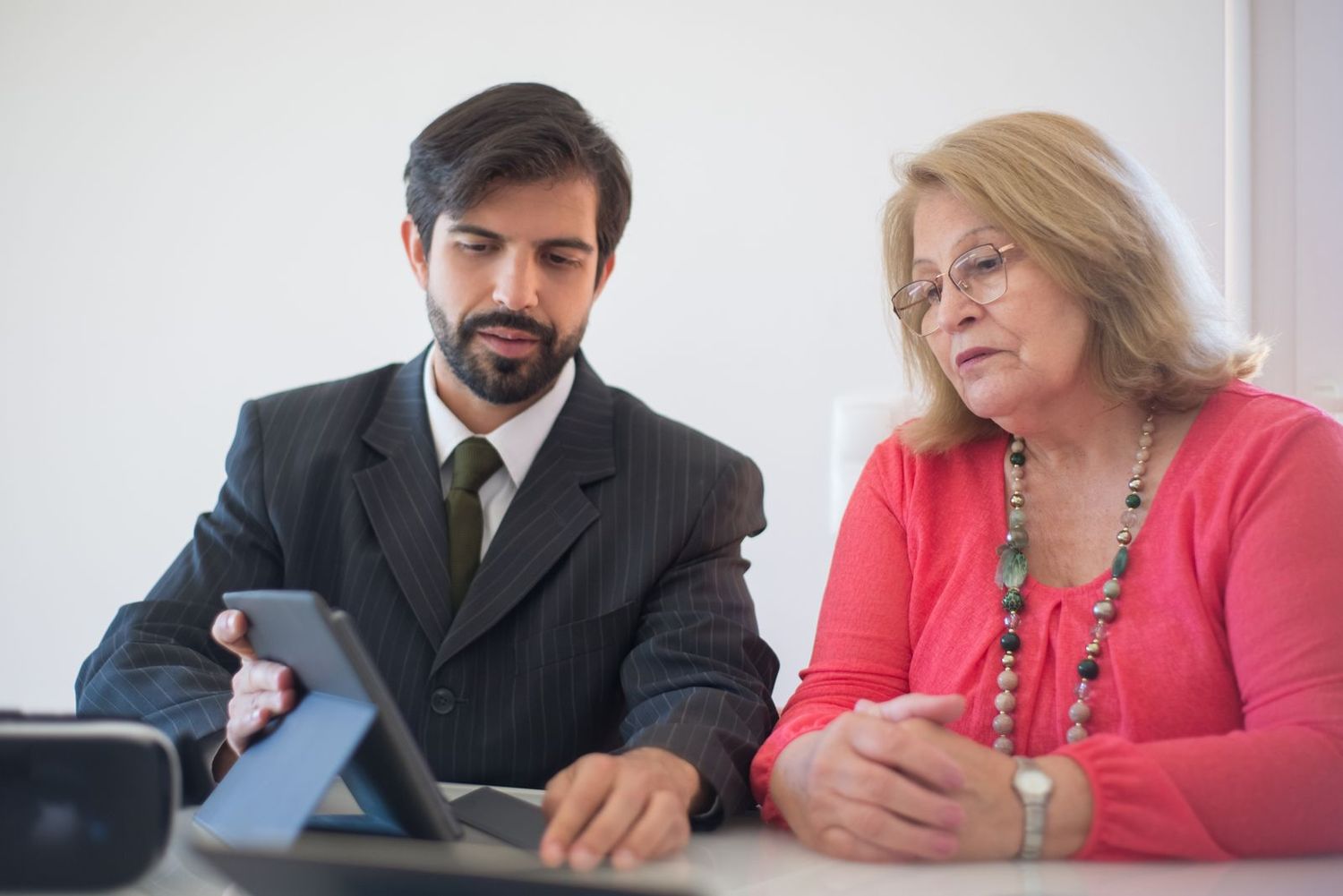 A financial adviser showing a client something on a tablet