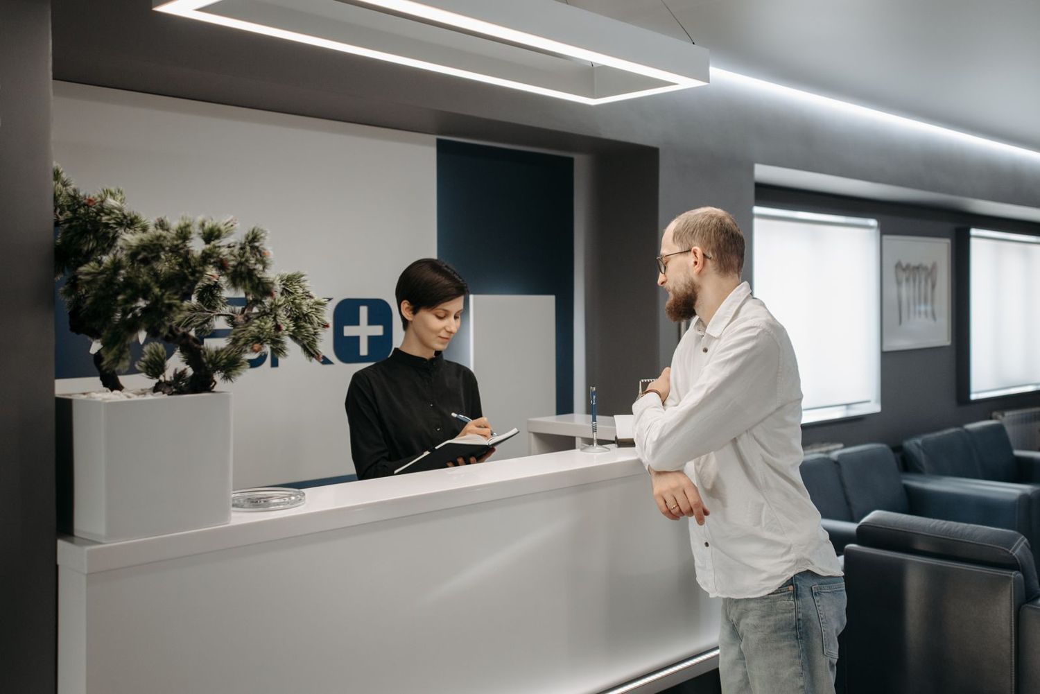 A patient being helped at a clinic reception desk