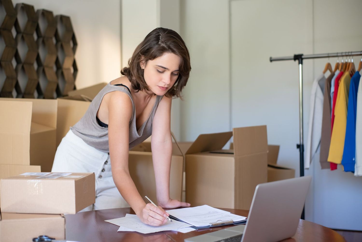 An online retailer preparing orders beside her laptop
