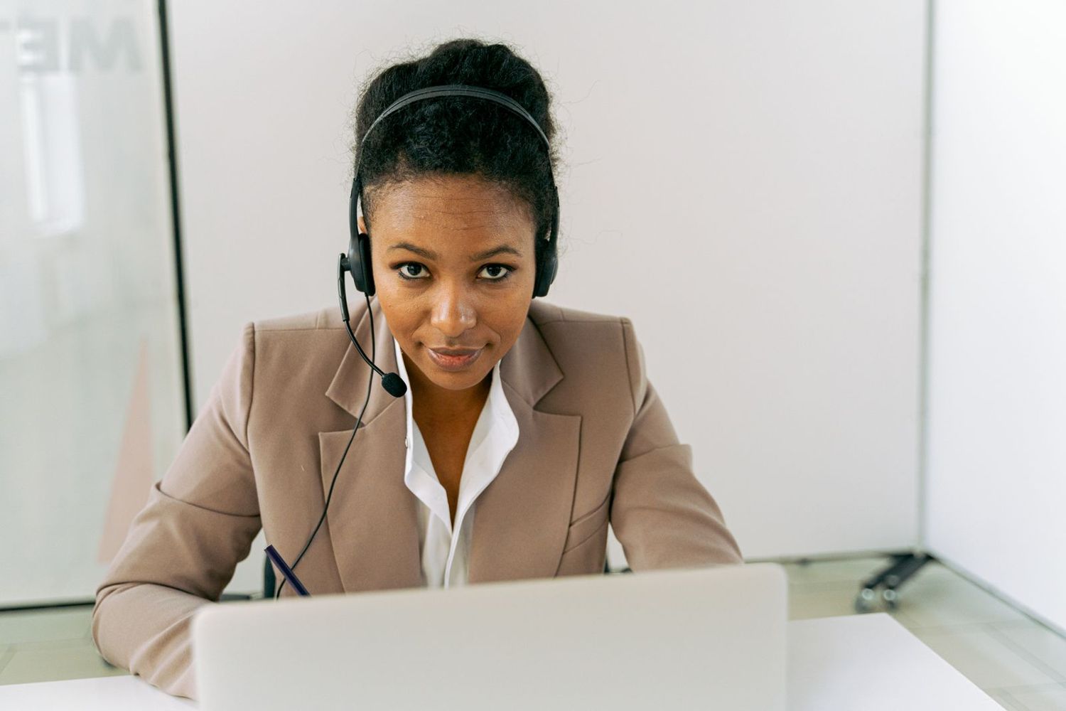 An agent with a headset working at her laptop